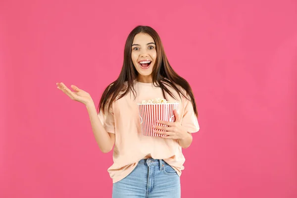 Mujer sorprendida con palomitas de maíz sobre fondo de color — Foto de Stock