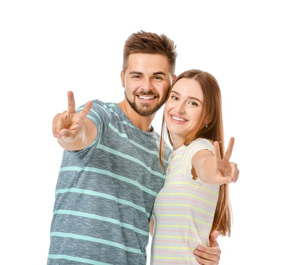 Ritratto di giovane coppia felice che mostra il gesto della vittoria su sfondo bianco — Foto Stock