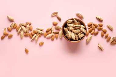 Renkli arkaplanda lezzetli bademler olan kase