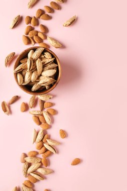 Renkli arkaplanda lezzetli bademler olan kase