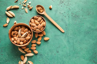 Renkli arkaplanda lezzetli bademler olan kaseler