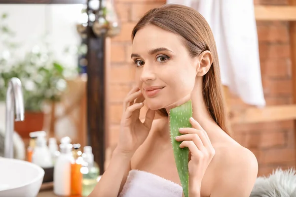 Beautiful young woman using aloe vera in bathroom — Stock Photo, Image