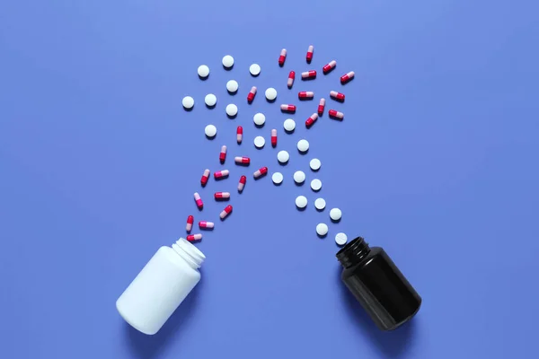 Vasi e diverse pillole sparse su sfondo a colori — Foto Stock