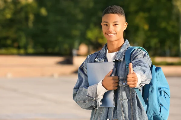 Портрет афроамериканського студента підліткового віку, який зображає великого пальця на відкритому повітрі. — стокове фото