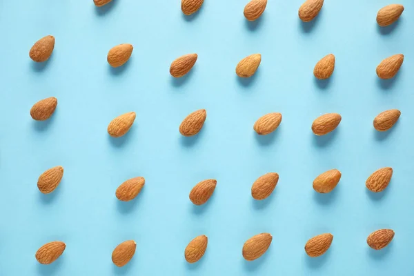 Many tasty almonds on color background — Stock Photo, Image