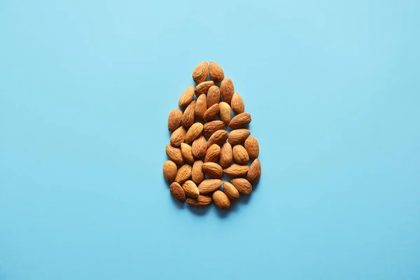 Many tasty almonds on color background — Stock Photo, Image