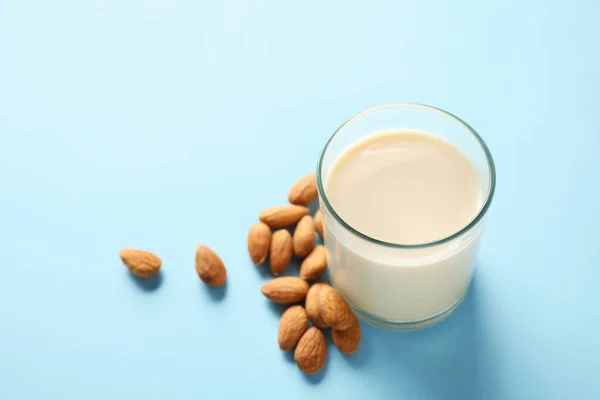 Renkli arkaplanda bir bardak lezzetli badem sütü — Stok fotoğraf