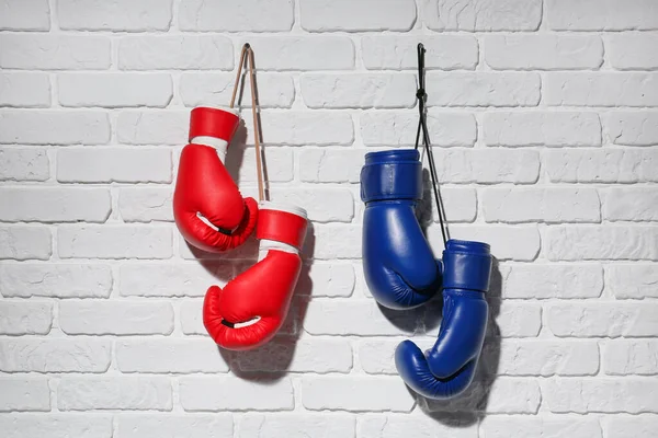 Guantes de boxeo colgados en pared de ladrillo — Foto de Stock