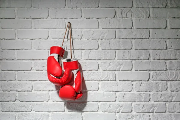 Par de guantes de boxeo colgados en la pared de ladrillo — Foto de Stock