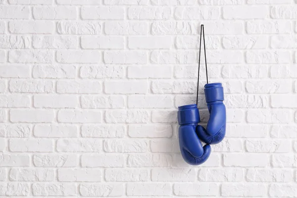 Pair of boxing gloves hanging on brick wall — Stock Photo, Image