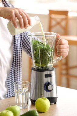 Adam evde sağlıklı smoothie yapıyor, yakın plan.