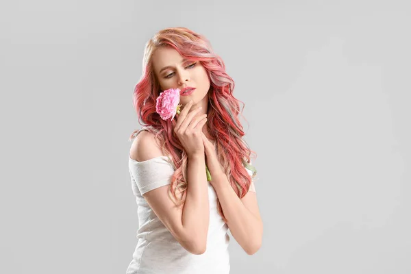 Gri Arkaplanda Tuhaf Saçları Çiçekleri Olan Güzel Bir Genç Kadın — Stok fotoğraf