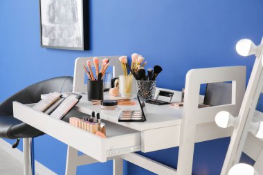 Modern soyunma odasında makyaj malzemesi olan masa.