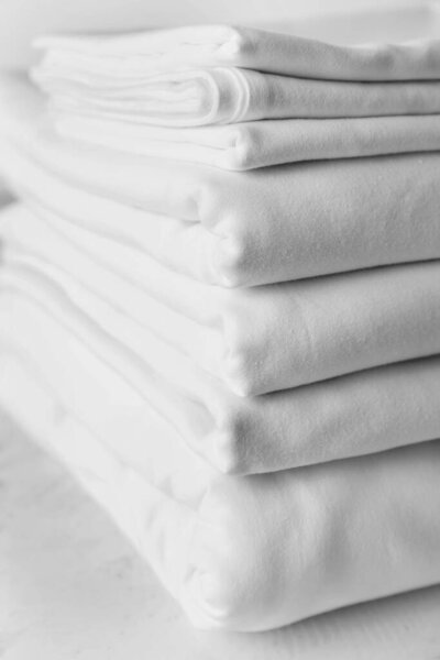Stack of clean bed sheets on table, closeup