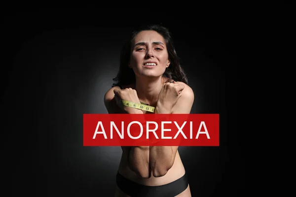 黒い背景に手首の周りのテープを測定するスキニー女性 拒食症の概念 — ストック写真