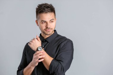 Gri arka planda şık saç stili olan yakışıklı adam.