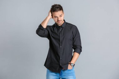 Gri arka planda şık saç stili olan yakışıklı adam.