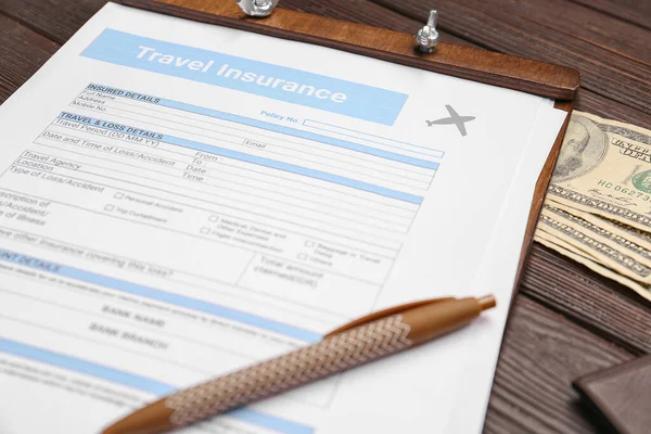 Travel insurance form with money on table