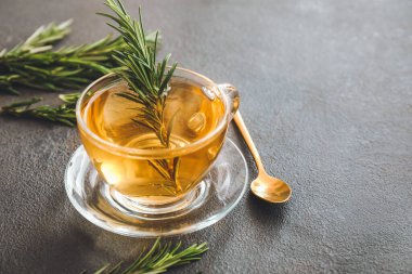 Siyah arka planda biberiyeli bir fincan sıcak çay.