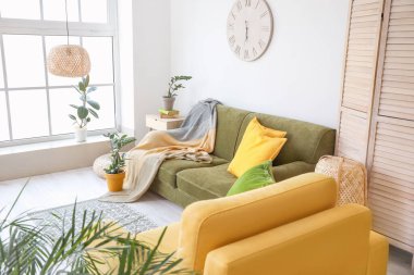 Kanepesi ve çiçekleri olan modern bir oda.