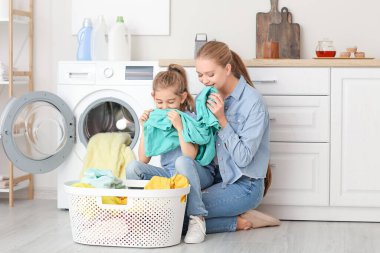 Anne ve küçük kızı evde çamaşır yıkıyorlar.