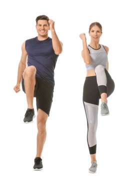 Beyaz arka planda spor yapan genç bir çift.