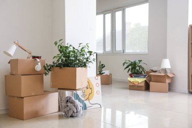 Taşındığı gün yeni dairede içinde eşyalar olan karton kutular.