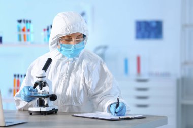 Laboratuvarda mikroskopla çalışan bilim adamı