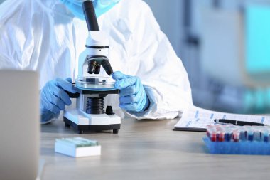 Laboratuvarda mikroskopla çalışan bilim adamı