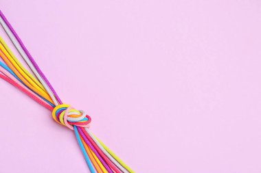 Renkli arka planda bağlanmış ipler. Birlik kavramı