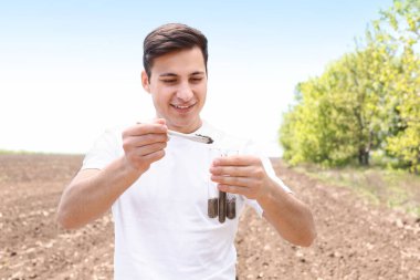 Agronomist tarladaki toprak örneklerini inceliyor