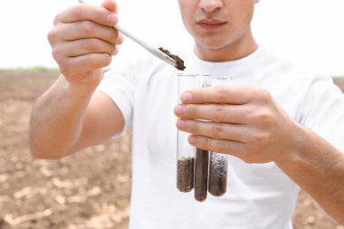 Agronomist tarladaki toprak örneklerini inceliyor
