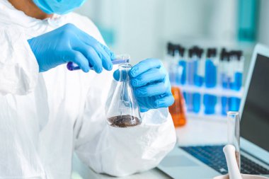 Bilimadamı laboratuvarda toprak örneklerini inceliyor