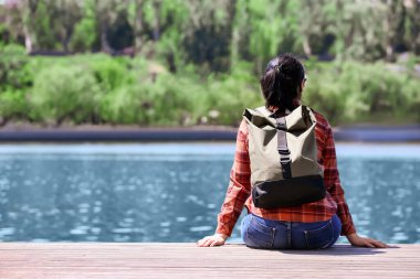 Nehir kenarında sırt çantalı bir kadın gezgin.