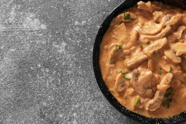 Gri arka planda lezzetli sığır stroganofu.