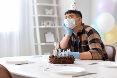 Üzgün Asyalı adam arkadaşsız doğum gününü kutluyor. Salgın kavramı