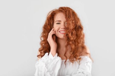 Açık arkaplanda güzel kızıl saçlı kadın portresi