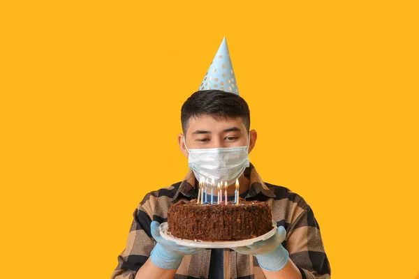 Homem Asiático Máscara Protetora Com Bolo Aniversário Fundo Cor Conceito — Fotografia de Stock