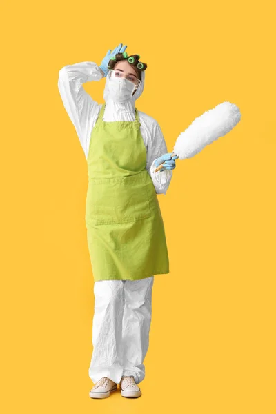 Müde Hausfrau Schutzkostüm Und Mit Staubpinsel Auf Farbigem Hintergrund — Stockfoto