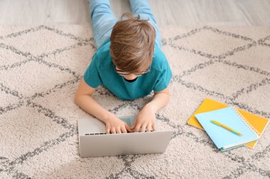 Evde ders çalışan sevimli küçük bir çocuk. Çevrimiçi eğitim kavramı