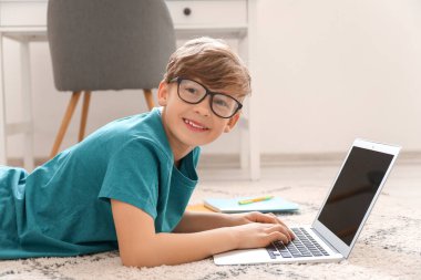 Evde ders çalışan sevimli küçük bir çocuk. Çevrimiçi eğitim kavramı