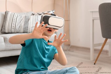 Evde VR gözlüklü şirin bir çocuk var.