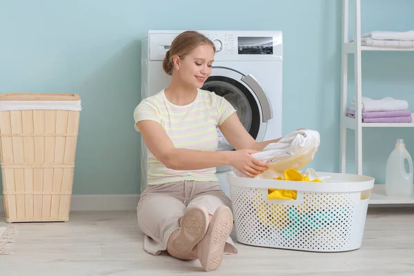 Evde çamaşır yıkayan genç bir kadın.