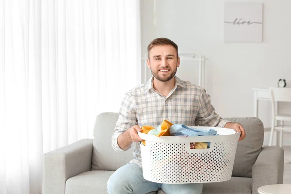 Young man with laundry at home