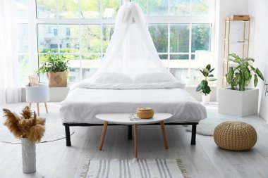 Odasında temiz çarşaf olan büyük, rahat bir yatak.