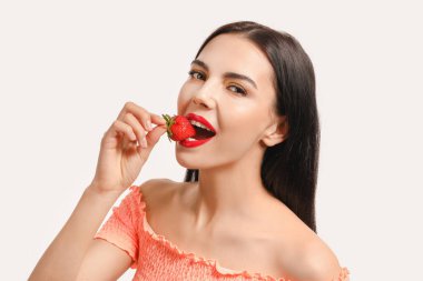 Beyaz arka planda çilekli seksi genç kadın.