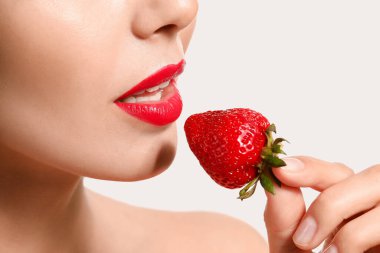 Beyaz arka planda çilekli seksi genç kadın, yakın plan.