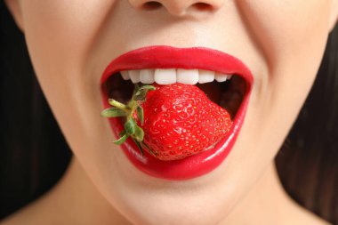 Ağzında çilek olan seksi genç kadın, yakın plan.