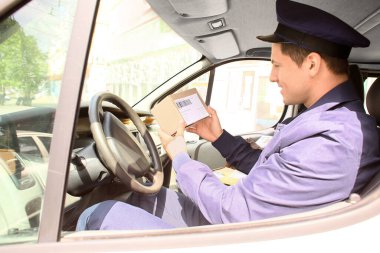 Arabadaki yakışıklı genç postacı.