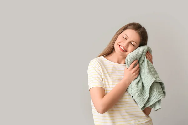 灰色の背景にきれいな洗濯をしている若い女性 — ストック写真